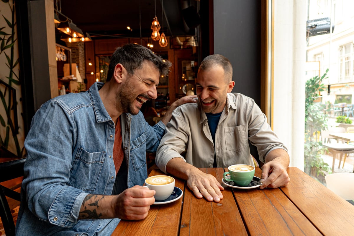 Two friends sharing stories and laughter over coffee in a cozy café